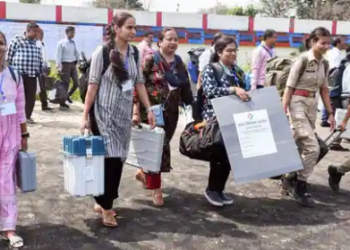 Polling officials leave for their respective polling stations after collecting EVMs