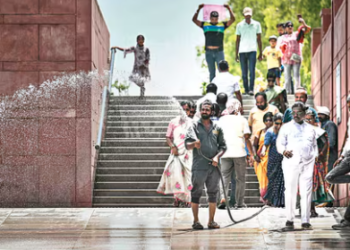 A worker sprinkles water on a subway to bring relief from the heat in Delhi. (AFP)