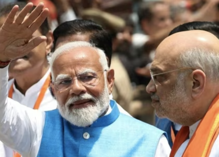 Prime Minister Narendra Modi waving to supporters as Union Home Minister Amit Shah looks on. (AFP file photo)