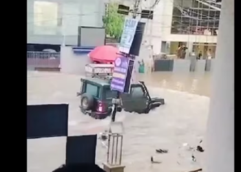 After an SUV passes the road, water hits the gate of the coaching institute, and the gates break as it is unable to withstand the pressure of flood waters.(@htTweets )