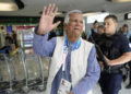 Nobel laureate Muhammad Yunus waves to the media at Charles de Gaulle's airport in Roissy, north of Paris, Wednesday. (AP)