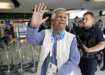 Nobel laureate Muhammad Yunus waves to the media at Charles de Gaulle's airport in Roissy, north of Paris, Wednesday. (AP)