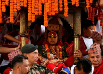 Living God Ganesh Rodin Shakya is presented in front of the crowd while being carried into his chariot during the annual Indra Jatra festival to worship Indra, Kumari