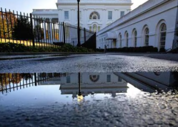 The White House is reflected in a pool of water from a ground sprinkler post-Election Day (AP)