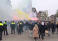 In this image taken from video, police stand guard as Maccabi Tel Aviv supporters light flares at the Dam square, in Amsterdam (AP Photo InterVision)(AP)
