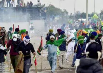 Farmers cover their faces with cloth as police fire tear gas during a protest at the Punjab-Haryana state Shambhu border in Punjab on December 8 (AFP)