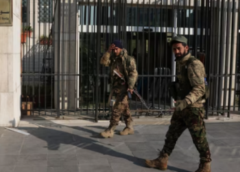 Rebel fighters walk in front of Syrian Central Bank, after rebels seized the capital and ousted President Bashar al-Assad, in Damascus, Syria, December 9, 2024.(REUTERS)