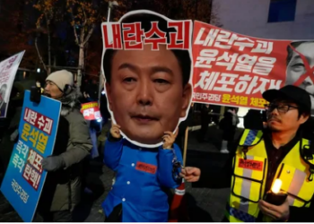 A participant wearing a mask of South Korean President Yoon Suk Yeol attends a rally demanding his impeachment outside the National Assembly in Seoul, South Korea,.The signs read "Arrest Yoon Suk Yeol."(AP)